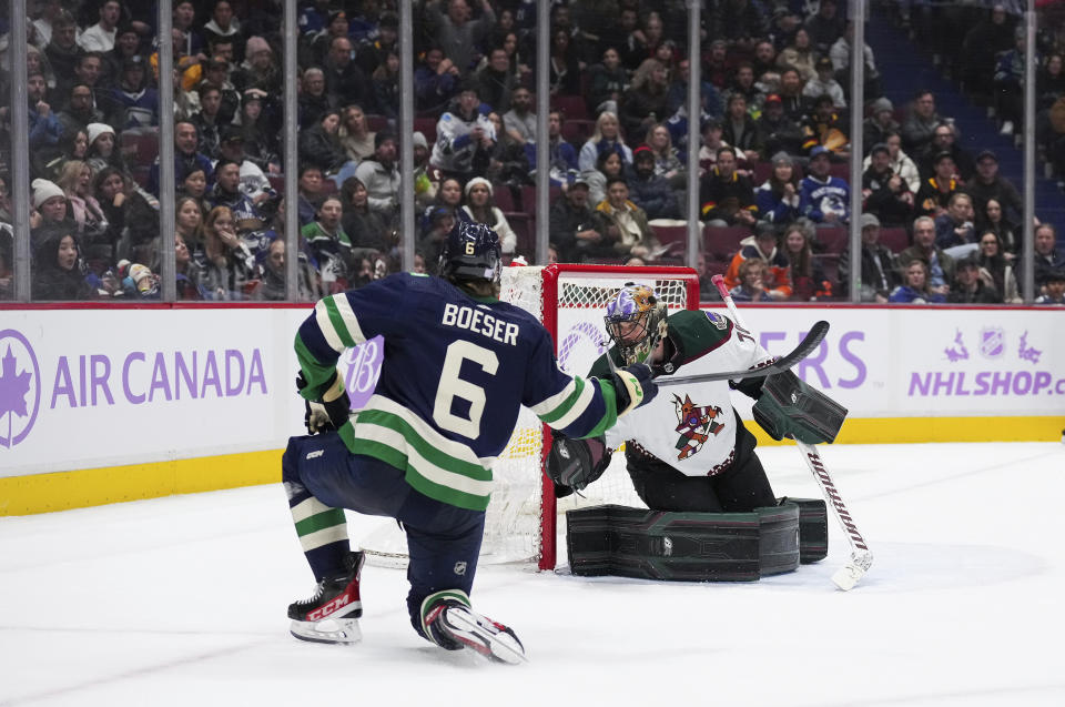 Vancouver Canucks' Brock Boeser (6) scores against Arizona Coyotes goalie Karel Vejmelka during the third period of an NHL hockey game Saturday, Dec. 3, 2022, in Vancouver, British Columbia. (Darryl Dyck/The Canadian Press via AP)