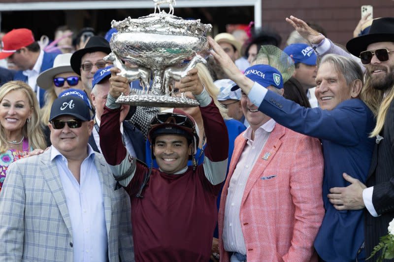 Jockey Luis Suez, winning jockey of the Belmont Stakes aboard Dornoch, celebrates in the winner's circle at Saratoga Race Course on Saturday in Saratoga Springs, N.Y. He is flanked by triner Danny Gargan (L), and Jason Werth (R), a former Major League Baseball player and part owner of Dornoch. Photo by Mark Abraham/UPI