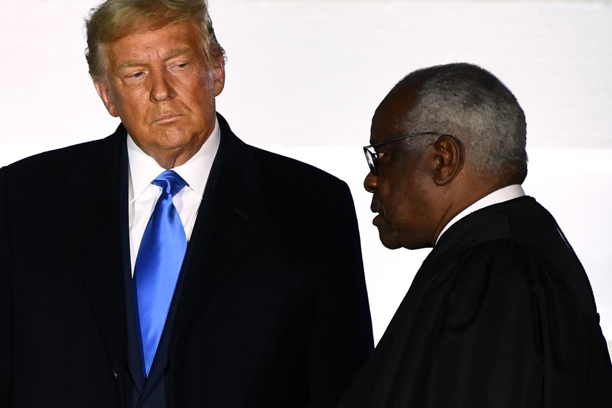 US President Donald Trump watches as Supreme Court Associate Justice Clarence Thomas swears in Judge Amy Coney Barrett (out of frame) as a US Supreme Court Associate Justice during a ceremony on the South Lawn of the White House October 26, 2020, in Washington, DC. 