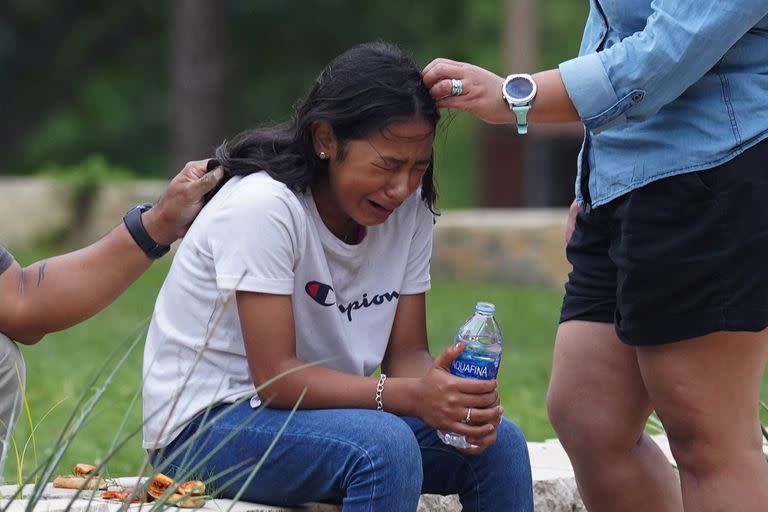 Una niña llora, consolada por dos adultos, afuera del Centro Cívico Willie de Leon, donde se ofrece asesoramiento de duelo en Uvalde, Texas