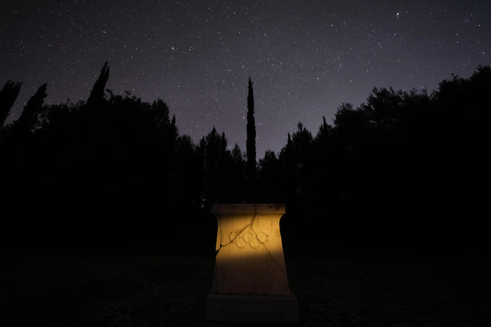 FILE - A marble altar with the Olympic rings stands under the night sky at the monument where is placed the heart of French Baron Pierre de Coubertin, in ancient Olympia, on Monday April 8, 2024. Born in 1863, Coubertin was the second president of the IOC. while the Ancient Olympics originated in Greece, its modern incarnation is very much a French affair. The Games were revived in the 1890s by a French nobleman, Baron Pierre de Coubertin—who now holds a questionable legacy. (AP Photo/Petros Giannakouris)