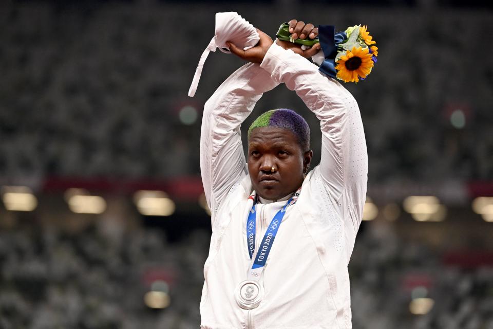 <p>Second-placed USA's Raven Saunders gestures on the podium with her silver medal after competing the women's shot put event during the Tokyo 2020 Olympic Games at the Olympic Stadium in Tokyo on August 1, 2021. (Photo by Ina FASSBENDER / AFP) (Photo by INA FASSBENDER/AFP via Getty Images)</p> 