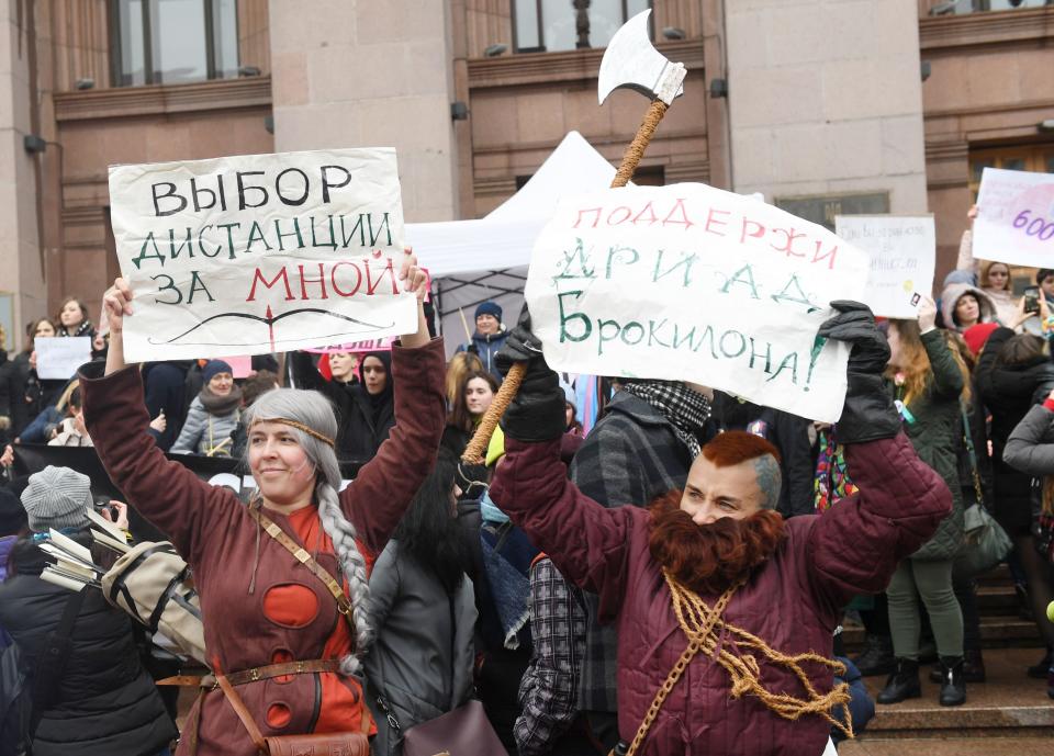 Costumed activists hold placards during&nbsp;a feminist march to mark International Women's Day.