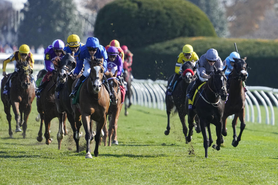 William Buick rides Mischief Magic, left in blue, leads the field to win the Breeders' Cup Juvenile Turf Sprint raceat the Keenelend Race Course, Friday, Nov. 4, 2022, in Lexington, Ky. (AP Photo/Darron Cummings)