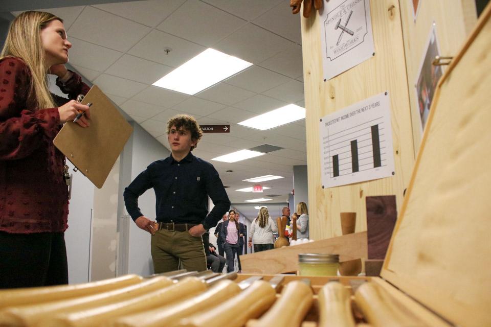 Liam Deniau-Young (right) discusses his business "The Spindle & The Chisel Woodworking" at the Entrepreneurship Challenge March 1.