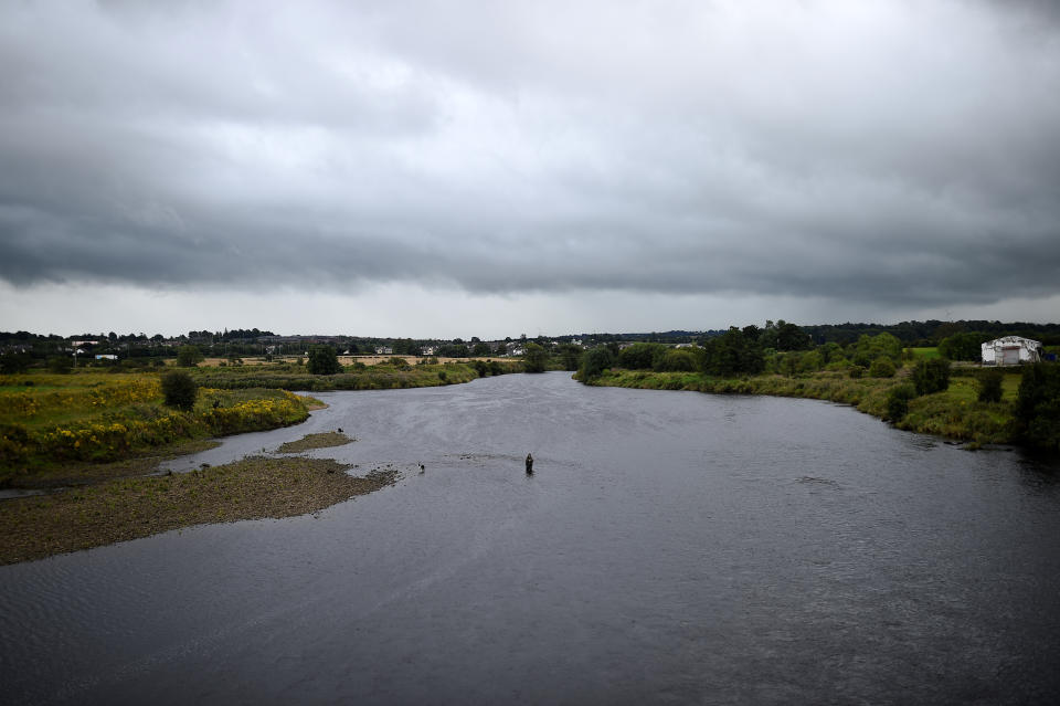 A man fishes in the river Foyle which marks the border between Ireland on the right and Northern Ireland on the left, in Strabane, Northern Ireland, August 16, 2017. REUTERS/Clodagh Kilcoyne