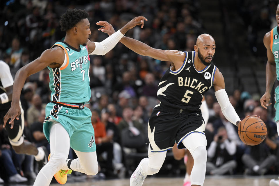 Milwaukee Bucks' Jevon Carter (5) drives against San Antonio Spurs' Josh Richardson during the second half of an NBA basketball game, Friday, Nov. 11, 2022, in San Antonio. (AP Photo/Darren Abate)