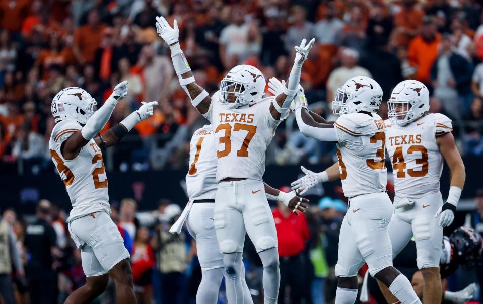 Texas linebacker Morice Blackwell Jr., center, celebrates with teammates during the second half of the Big 12 championship game win over Oklahoma State. The Longhorns are in the College Football Playoff for the first time, chasing their first national championship for the first time since the 2009 season.