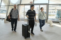 American's Andy Huynh, center, and Alex Drueke, left, arrive at the TWA Hotel on Friday, Sept. 23, 2022 in New York. The two U.S. military veterans who disappeared three months ago while fighting Russia with Ukrainian forces were among 10 prisoners, including five British nationals, released this week by Russian-backed separatists as part of a prisoner exchange mediated by Saudi Arabia. (AP Photo/Andres Kudacki)