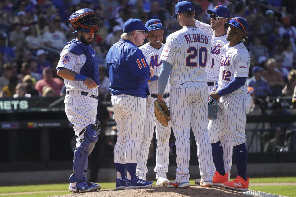 New York Mets manager Buck Showalter, second from left, goes to make a pitching change, during a baseball game against San Diego Padres, Wednesday, April 12, 2023, in New York. (AP Photo/Bebeto Matthews)