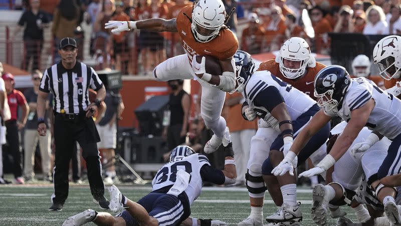 Texas running back Jonathon Brooks (24) is upended by BYU safety Crew Wakley (38) during a Big 12 football game in Austin, Texas, on Oct. 28, 2023. 