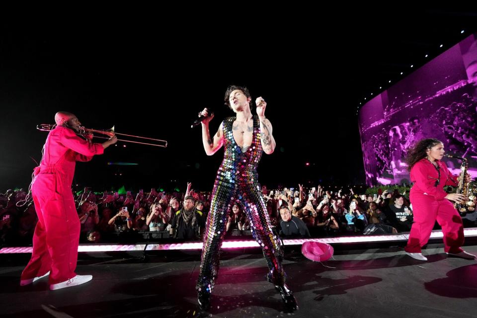 A man wearing a sparkly outfit and dancing on a stage