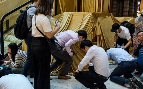 Some office workers took shelter from the tear gas inside a mall - Credit: Nicole Tung/Bloomberg