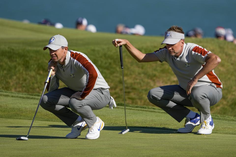 Team Europe's Ian Poulter and Team Europe's Rory McIlroy line up a putt on the sixth hole during a four-ball match the Ryder Cup at the Whistling Straits Golf Course Saturday, Sept. 25, 2021, in Sheboygan, Wis. (AP Photo/Jeff Roberson)