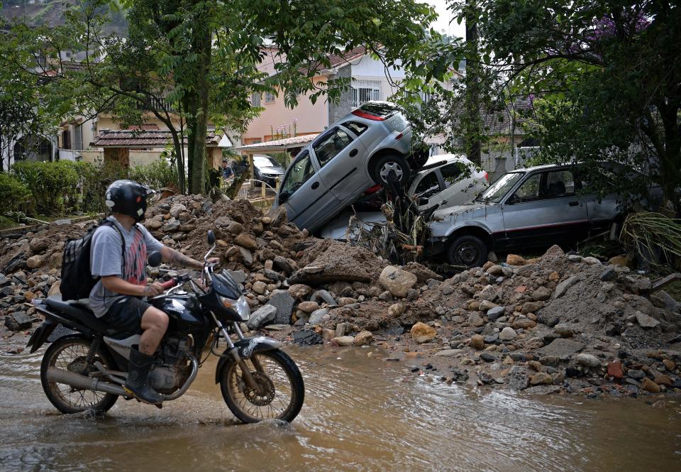 Cars and earth litter streets after being swept away by flood waters.