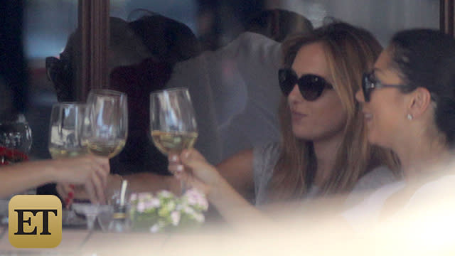 Christine Ouzounian looks to be enjoying herself despite all the recent drama in her life. The 28-year-old former nanny of Ben Affleck and Jennifer Garner was snapped having lunch at Beverly Hills restaurant Il Pastaio on Tuesday, all smiles while enjoying glasses of white wine with two girlfriends. Ouzounian clearly appeared to be in a good mood, despite a photo having leaked yesterday of her on a private jet to Las Vegas with 42-year-old Affleck and the New England Patriots quarterback Tom Brady, which reignited scrutiny of her relationship with the actor. The trip -- which was taken without Affleck's three kids -- also raised red flags for her friends, a source tells ET. FameFlynet FameFlynet <strong>WATCH: Ex-Nanny's Las Vegas Trip with Ben Affleck and Tom Brady Raised Red Flags for Friends, Source Says</strong> According to an eyewitness, Ouzounian was "grinning and very happy" during the two-hour meal, and her and her pals "toasted every time" as they ordered a few rounds of wine. She also obviously wasn't in hiding, requesting an outdoor table and "flirting with the waiters at the restaurant" -- even kissing a few of them on the cheek and showing them photos on her iPhone -- the eyewitness says. FameFlynet FameFlynet FameFlynet <strong>MORE: The NannyGate Diaries: A Complete Timeline of Ben Affleck's Divorce Scandal</strong> Ouzounian was then spotted driving off in her brand new Lexus with her friends after the boozy lunch. FameFlynet FameFlynet ET obtained an Instagram from her account posted on Monday, in which she poses next to what appears to be the new Lexus IS convertible -- a car that starts at about $43,000. "Keep Calm and meet my new drop top Lexi," Ouzounian wrote, accompanied by a smiley face emoji. <strong>WATCH: Ben Affleck Meets With Ex-Nanny -- See the Pic That Sparked the Scandal</strong> Ouzounian returned to a Santa Monica home after lunch, but ET can confirm she was previously staying at the pricey Hotel Bel-Air since the scandal broke, where rooms run about $1,000 or more a night. Her activities included dining at Wolfgang Puck's restaurant and treating herself to spa treatments, spending a reported tens of thousands in all. According to a source, Affleck wasn't spotted at the hotel, although she reportedly told friends that she and the A-list actor would have romantic trysts there, starting last spring, <em> People</em> reports. Garner and Affleck announced their divorce after 10 years of marriage shortly after the Las Vegas trip. Affleck's rep has previously slammed reports that the <em>Batman v. Superman: Dawn of Justice</em> star is romantically involved with Ouzounian, calling them "complete garbage" and "full of lies." <strong>WATCH: EXCLUSIVE -- Ben Affleck's Former Nanny Shows Off a Brand New Lexu</strong> <strong>s </strong> However, Affleck and Ouzounian were photographed during a late-night meet-up on July 17, which a source exclusively told ET that she actually tipped off the paparazzi about so that they could get pictures of her and Affleck together. Watch below: