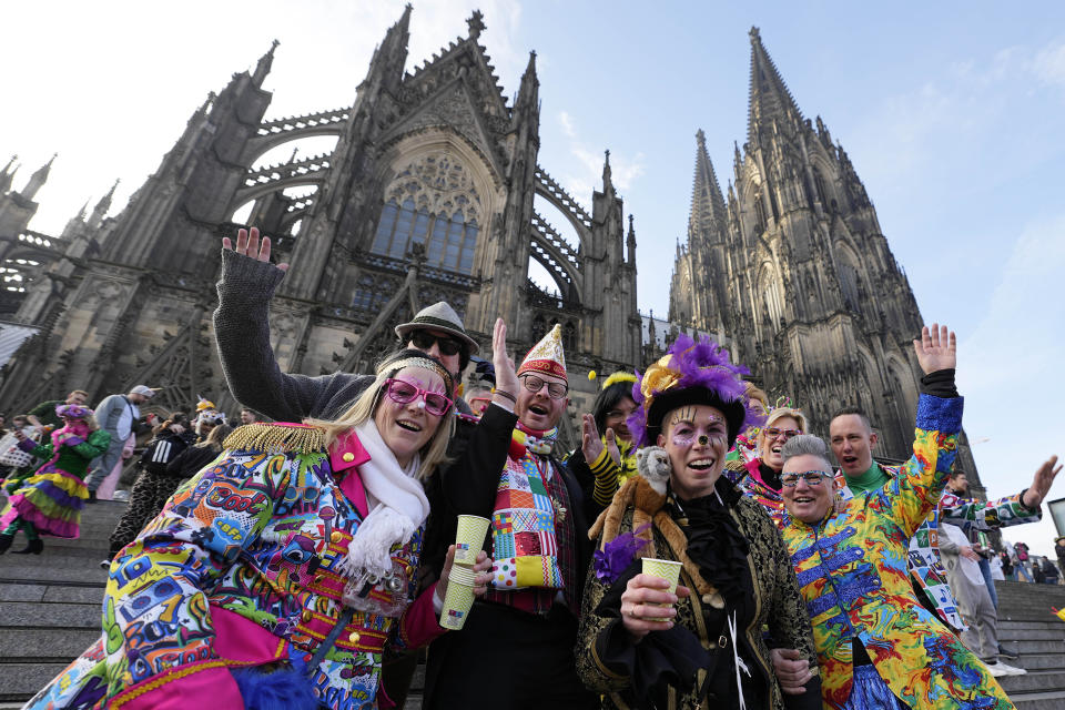 Revellers pose in front of the Cologne Cathedral at the start of the street carnival in Cologne, Germany, Thursday, Feb. 16, 2023. Hundreds of thousands will celebrate the carnival without any coronavirus restrictions in the streets of the German carnival capital. (AP Photo/Martin Meissner)