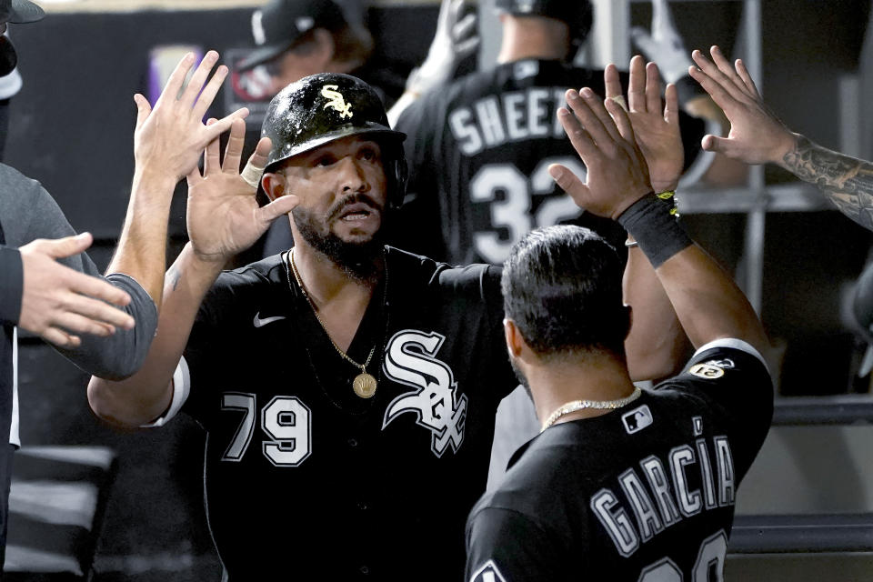 Chicago White Sox's Jose Abreu is congratulated in the dugout after scoring on a single by Yasmani Grandal during the sixth inning of the team's baseball game against the Los Angeles Angels on Wednesday, Sept. 15, 2021, in Chicago. (AP Photo/Charles Rex Arbogast)