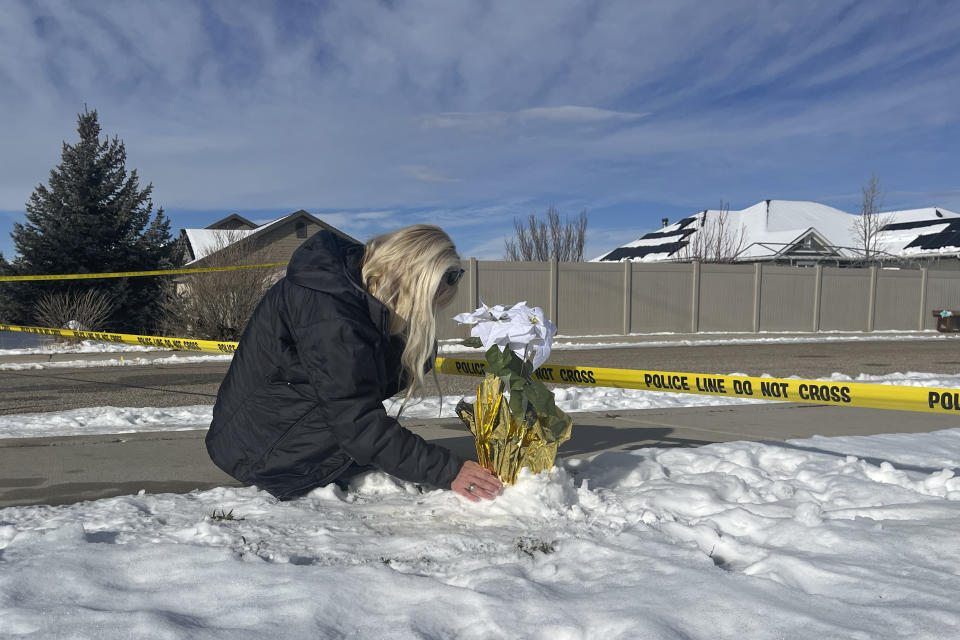 Sharon Huntsman, a member of The Church of Jesus Christ of Latter-day Saints from Cedar City, Utah, leaves flowers outside a home where eight family members were found dead in Enoch, Utah, Thursday, Jan. 5, 2023. Officials said Michael Haight, 42, took his own life after killing his wife, mother-in-law and the couple's five children. (AP Photo/Sam Metz)