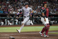 Colorado Rockies' Nolan Jones scores a run against the Arizona Diamondbacks on a sacrifice fly out by Ryan McMahon in the fifth inning during a baseball game, Saturday, March 30, 2024, in Phoenix. (AP Photo/Rick Scuteri)