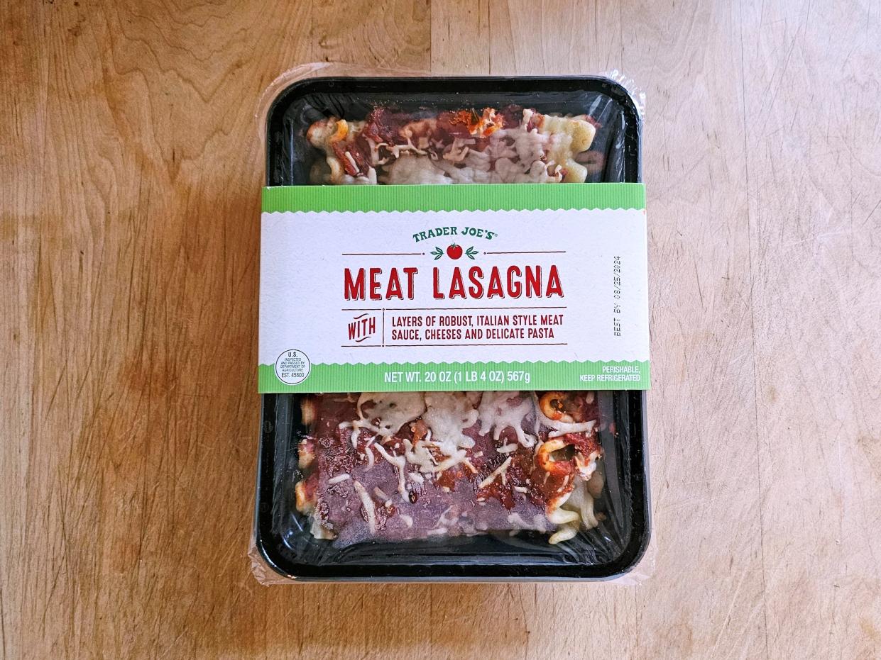 A box of Trader Joe's meat lasagna against a wooden background.