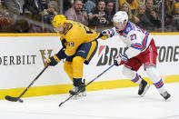 New York Rangers defenseman Nils Lundkvist (27) hangs onto the jersey of Nashville Predators' Roman Josi (59) in the second period of an NHL hockey game Thursday, Oct. 21, 2021, in Nashville, Tenn. (AP Photo/Mark Humphrey)