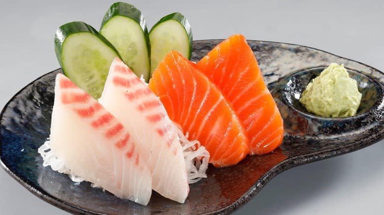 Close-up of a plate of sashimi with cucumber and wasabi