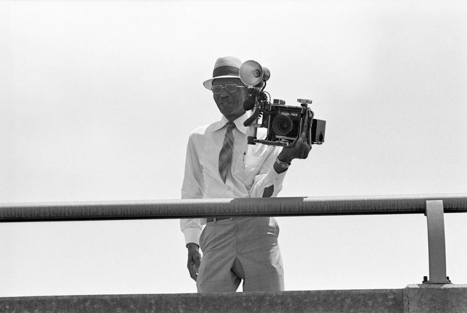 Fort Worth photographer Calvin Littlejohn is seen on a bridge documenting Juneteenth parade festivities on his Graflex camera in 1983.
