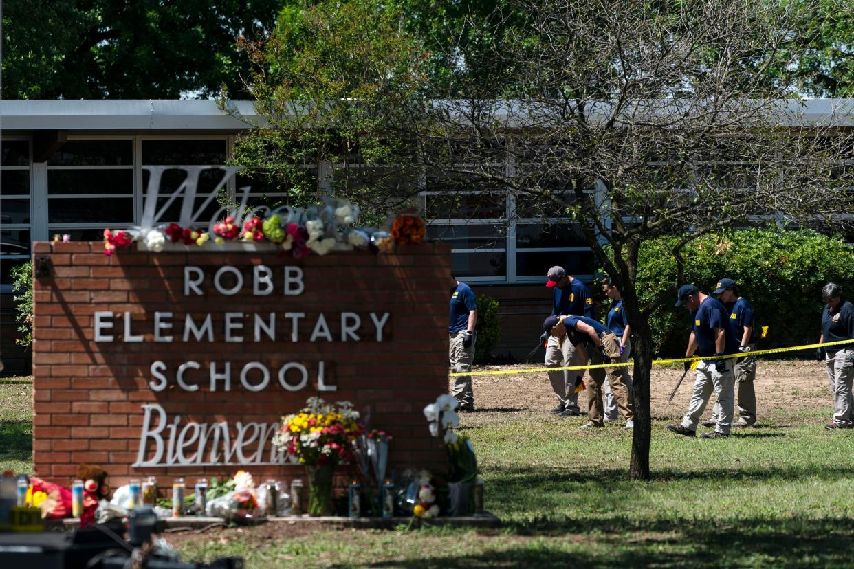 Investigators search for evidences outside Robb Elementary School in Uvalde, Texas, May 25, 2022, after an 18-year-old gunman killed 19 students and two teachers. 