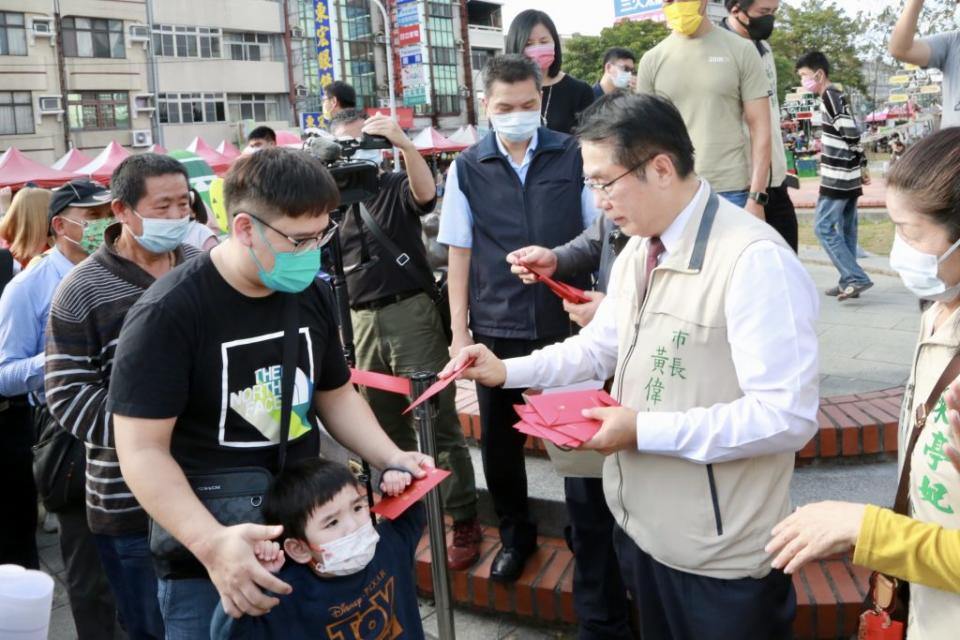 市長黃偉哲（右）到新化年貨大街發金兔紅包。 （記者黃文記攝）