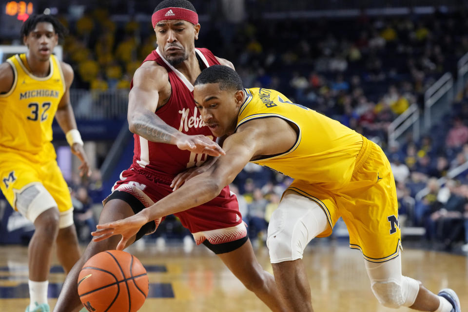 Michigan guard Nimari Burnett (4) reaches for the ball next to Nebraska guard Jamarques Lawrence during the second half of an NCAA college basketball game, Sunday, March 10, 2024, in Ann Arbor, Mich. (AP Photo/Carlos Osorio)