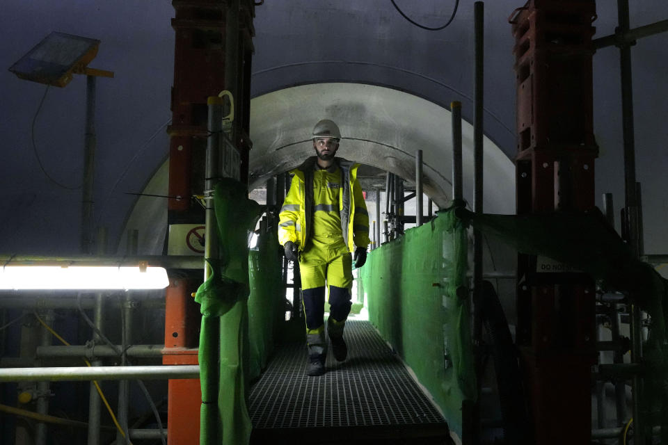 A worker walks at the construction site of a nuclear reactor at Hinkley Point C nuclear power station in Somerset, England, Tuesday, Oct. 11, 2022. Nuclear power is generated through fission, the process of splitting uranium atoms. The energy released by fission turns water into steam to spin a turbine that generates electricity, a process which doesn’t emit planet-warming gases into the atmosphere.