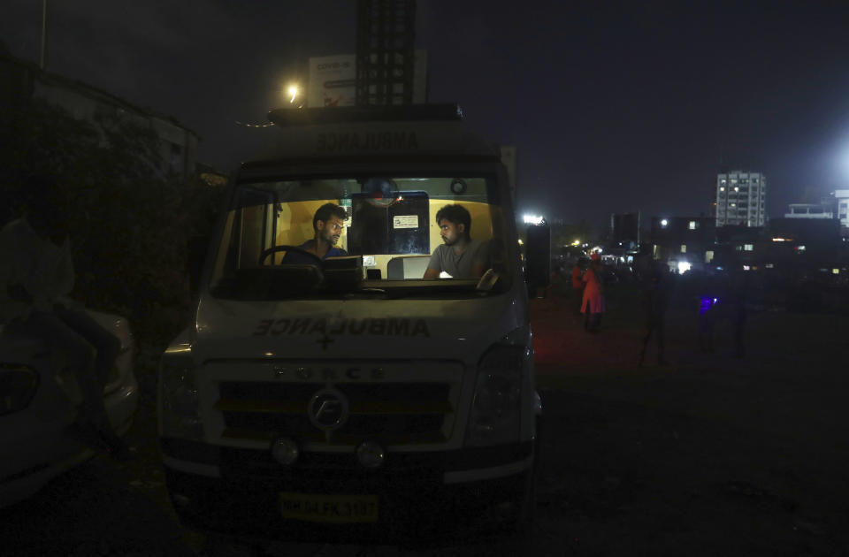 Izhaar Hussain Shaikh, left, an ambulance driver who works for HelpNow, an initiative to help the stretched services of first responders, chats with his helper Shahrukh Shaikh as they wait for a call in Mumbai, India May 29 2020. It’s an exhausting job and Shaikh's daily shifts are grueling, sometimes even stretching to 16 hours. For a city that has a history of shortage of ambulances and where coronavirus pandemic has claimed hundreds of lives, putting the health care system under immense strain, every help counts. (AP Photo/Rafiq Maqbool)