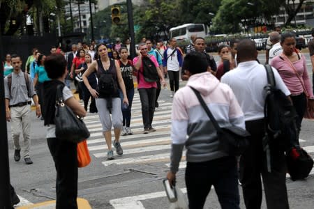 People walk on the street during a blackout in Caracas