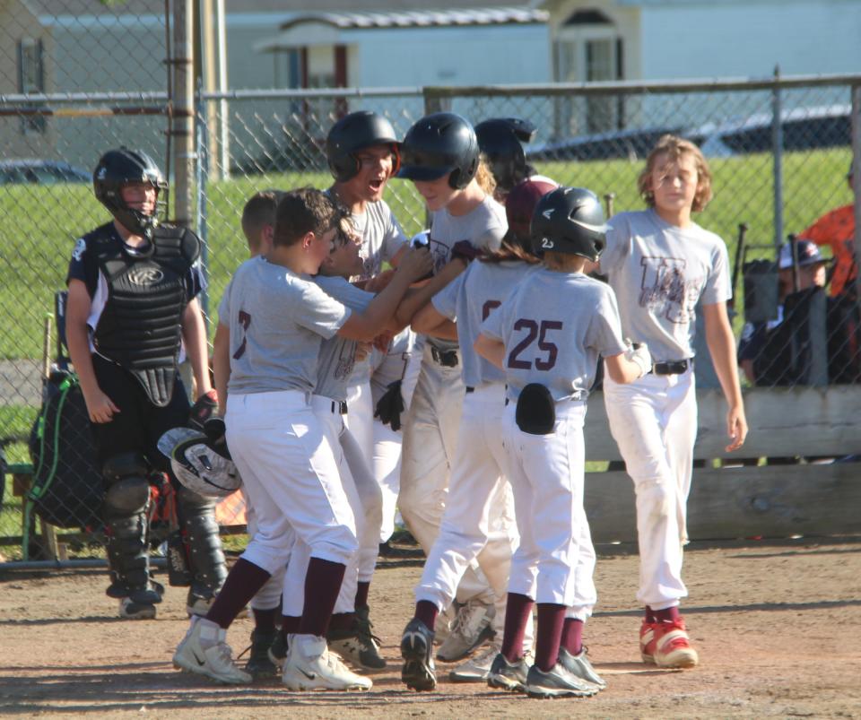 Union City's Tucker Zweng is greeted at home by his teammates after his first inning home run versus Quincy on Wednesday