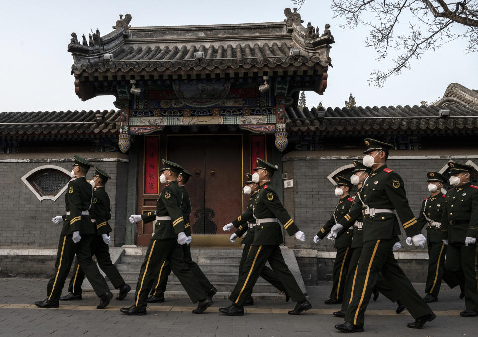 BEIJING, CHINA - NOVEMBER 22: Members of the Peoples Armed Police wear protective masks to protect against the spread of COVID-19 while marching in a foreign embassy area on November 22, 2022 in Beijing, China. In an effort to try to bring rising cases under control, the local government on Friday closed many stores and restaurants for inside dining, switched  schools to online studies, and asked people to work from home. Though the government recently revised its COVID strategy, it has said it will continue to stick to its strict zero tolerance policy with mandatory testings, quarantines and lockdowns in many areas in an effort to control the spread of the virus. (Photo by Kevin Frayer/Getty Images)