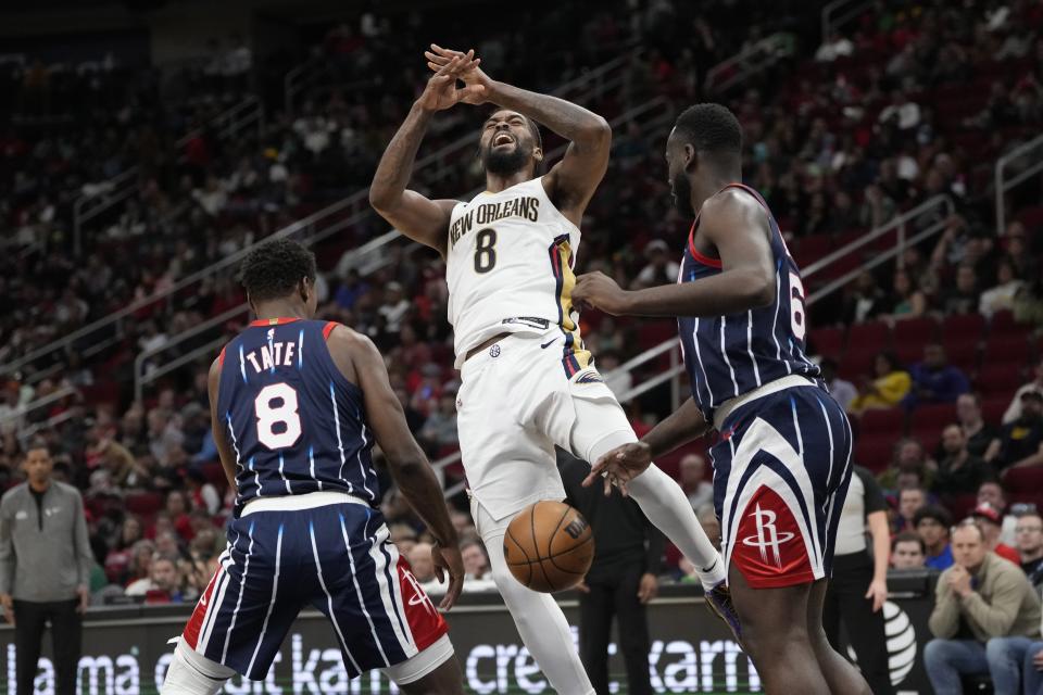 New Orleans Pelicans' Naji Marshall (8) loses the ball as Houston Rockets' Jae'Sean Tate (8) and Usman Garuba defend during the second half of an NBA basketball game Friday, March 17, 2023, in Houston. The Rockets won 114-112. (AP Photo/David J. Phillip)