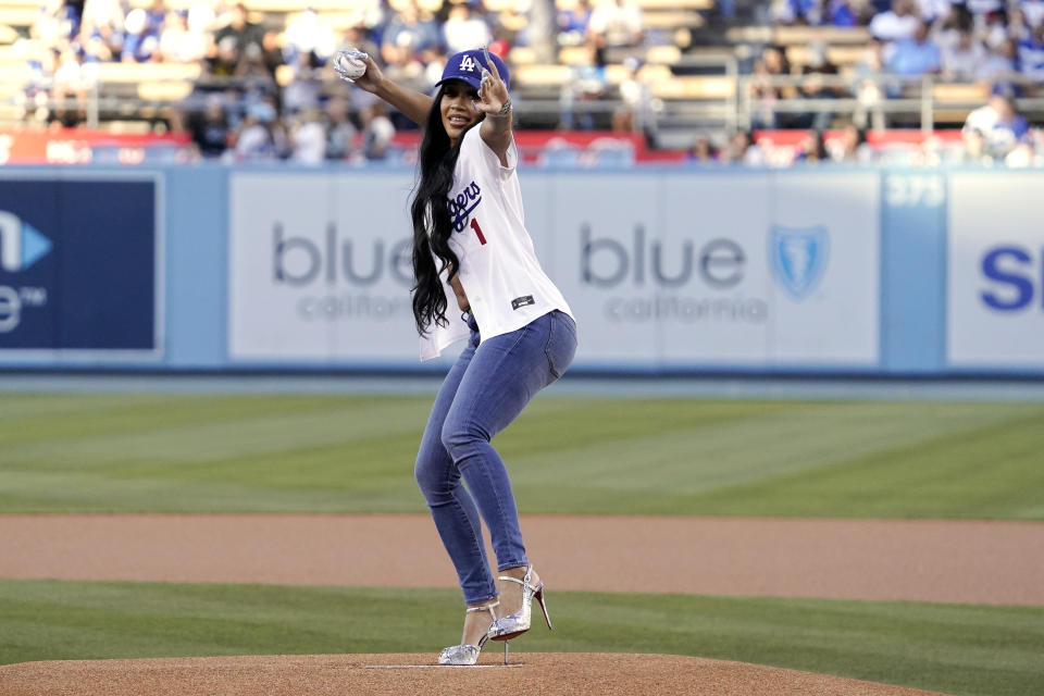 Entertainer Saweetie throws out the ceremonial first pitch prior to a baseball game between the Los Angeles Dodgers and the Chicago Cubs Thursday, July 7, 2022, in Los Angeles. (AP Photo/Mark J. Terrill)