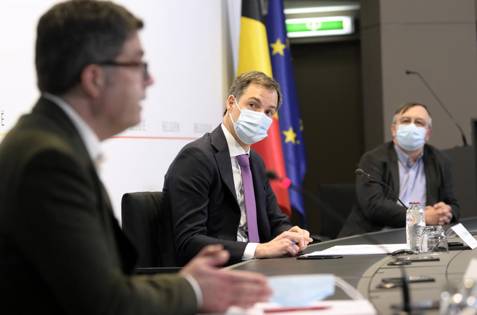 Belgium's Prime Minister Alexander De Croo, center, attends a media conference with Belgium's virologist Steven Van Gucht and Dr. Yves Van Laethem at the prime minister's office in Brussels, Monday, Feb. 22, 2021. The government on Monday presented scientific projections of the spread of the COVID-19 pandemic in Belgium, indicating it would be very risky to extensively loosen the current restrictions over the coming weeks. (Philip Reynaers, Pool via AP)