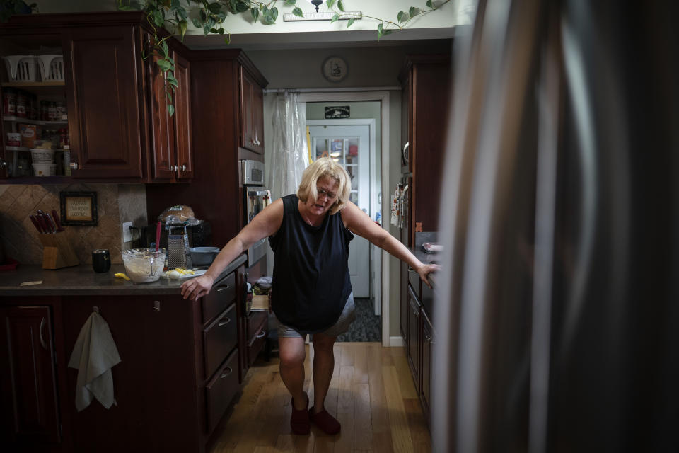 Susan Ryder supports herself as she pauses to reflect on her experiences of the "ups and downs" of caregiving for her mother over the past year, Tuesday, Nov. 30, 2021, in Rotterdam Junction, N.Y. (AP Photo/Wong Maye-E)