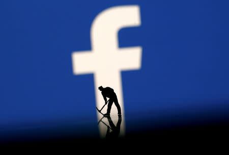 A figurine is seen in front of the Facebook logo in this illustration taken, March 20, 2018. REUTERS/Dado Ruvic/Illustration/Files