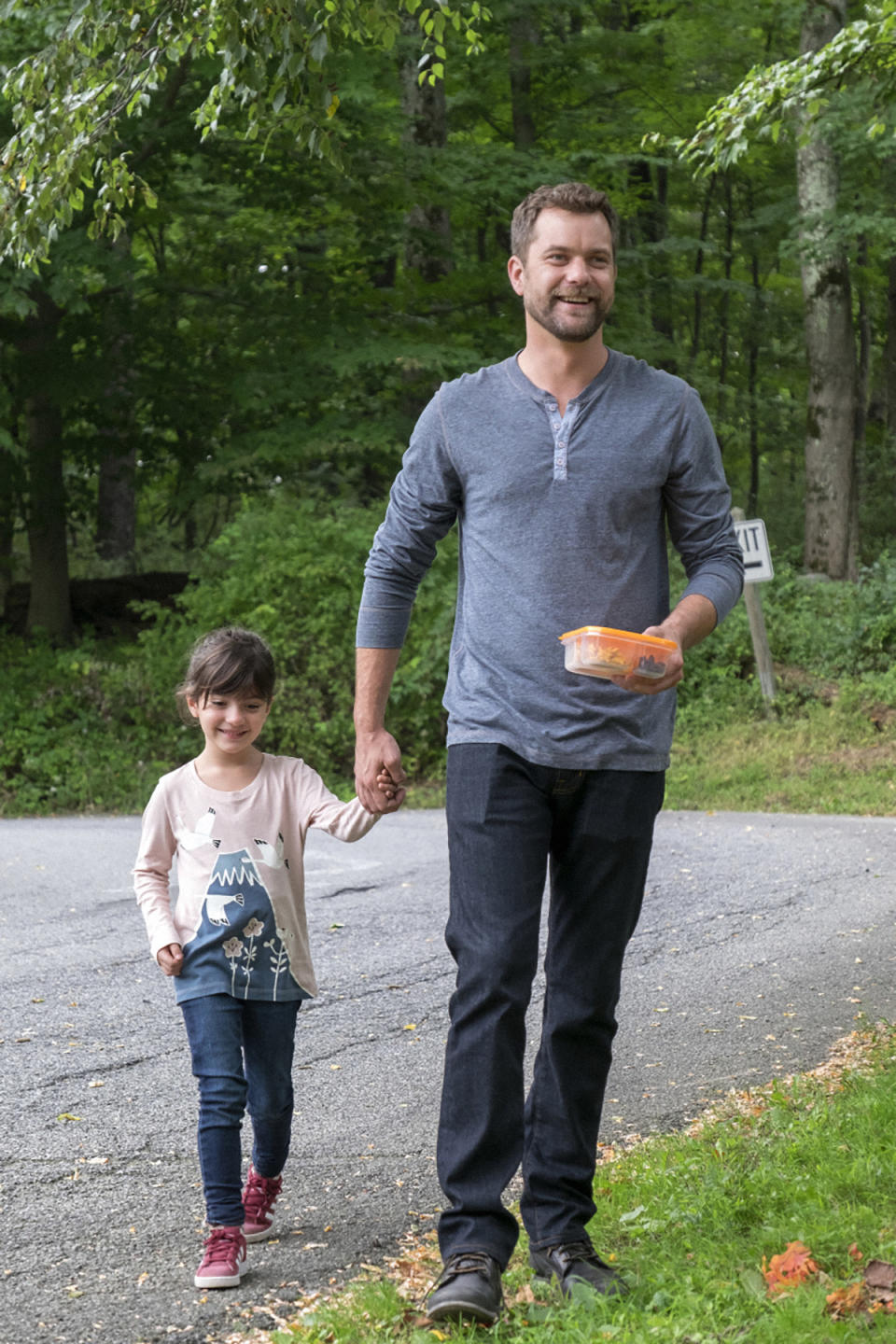 Joshua smiling and holding a child's hand