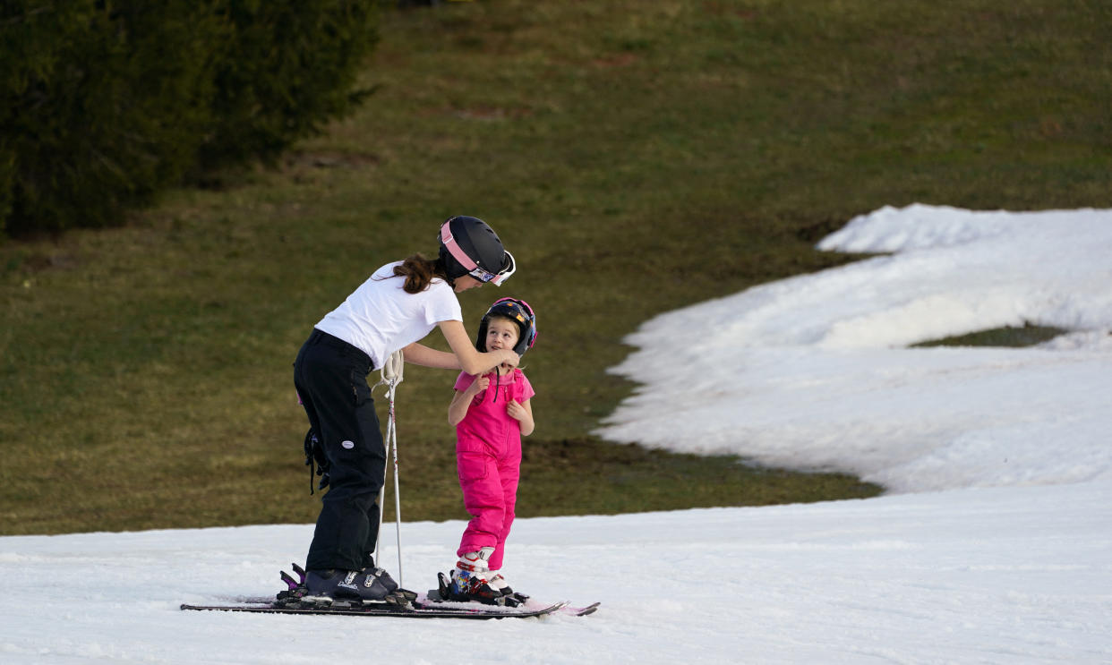 Skiers on man-made snow wear T-shirts.