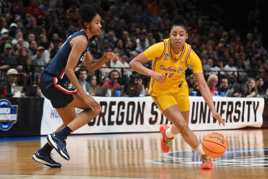 Southern California guard JuJu Watkins (12) tries to get around UConn guard Qadence Samuels during the second half of an Elite Eight college basketball game in the women’s NCAA Tournament, Monday, April 1, 2024, in Portland, Ore. (AP Photo/Steve Dykes)