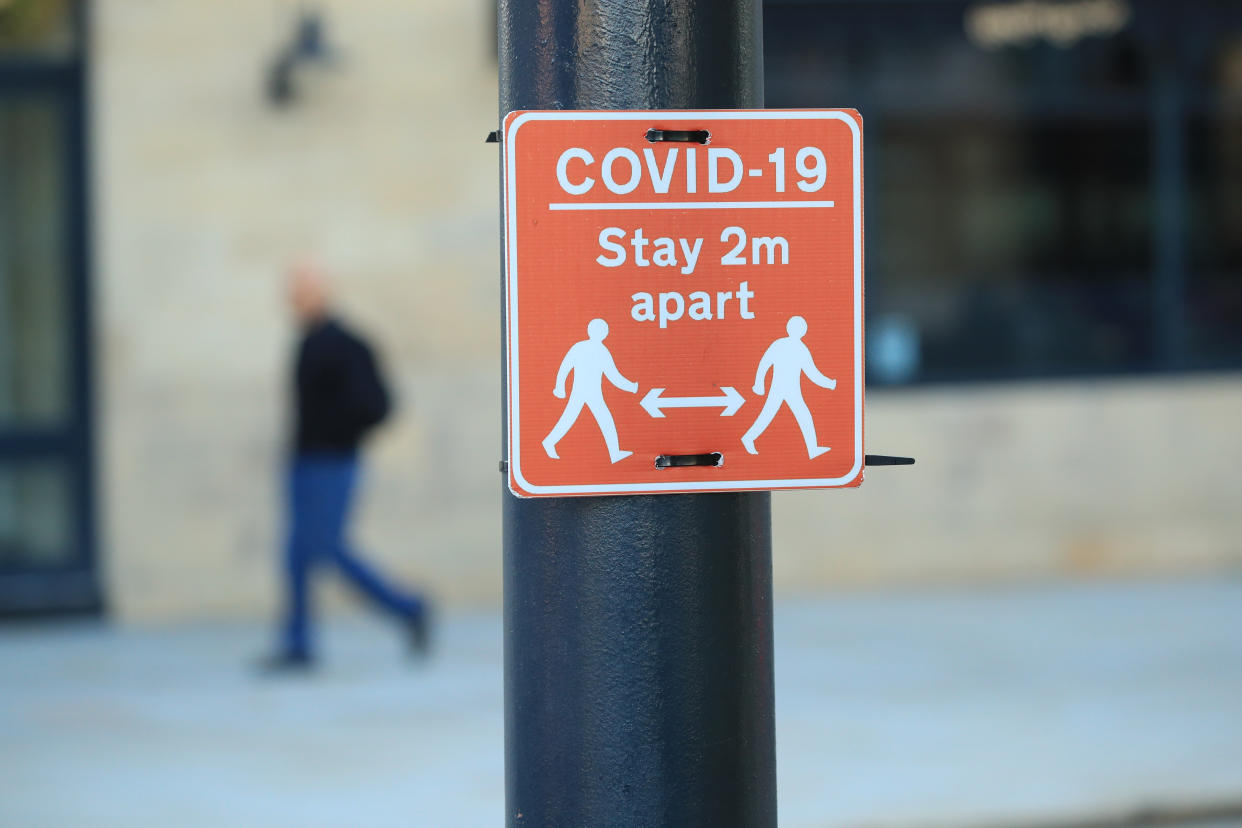 A sign advising people to stay two metres apart on a lamppost in the centre of Bradford, West Yorkshire, one of the areas where new measures have been implemented to prevent the spread of coronavirus. Stricter rules have been introduced for people in Greater Manchester, parts of East Lancashire, and West Yorkshire, banning members of different households from meeting each other indoors.