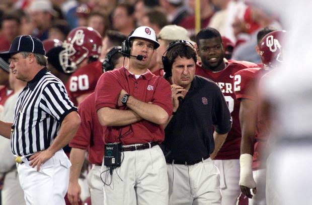 Mike Leach (right) stands on the sideline with Bob Stoops during the 1999 Bedlam game.