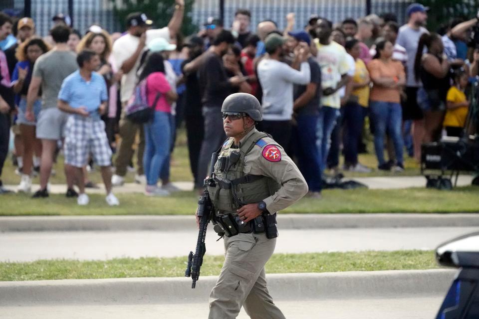 RETRANSMISSION TO CORRECT CITY TO ALLEN, TEXAS - A law enforcement officer walks as people are evacuated from a shopping center where a shooting occured Saturday, May 6, 2023, in Allen, Texas. (AP Photo/LM Otero)