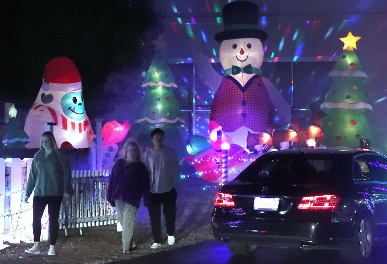 On foot or by car, visitors check out the Christmas decorations, Wednesday, Dec. 21, 2022, at the Twi-Light II Motel in Holly Hill.