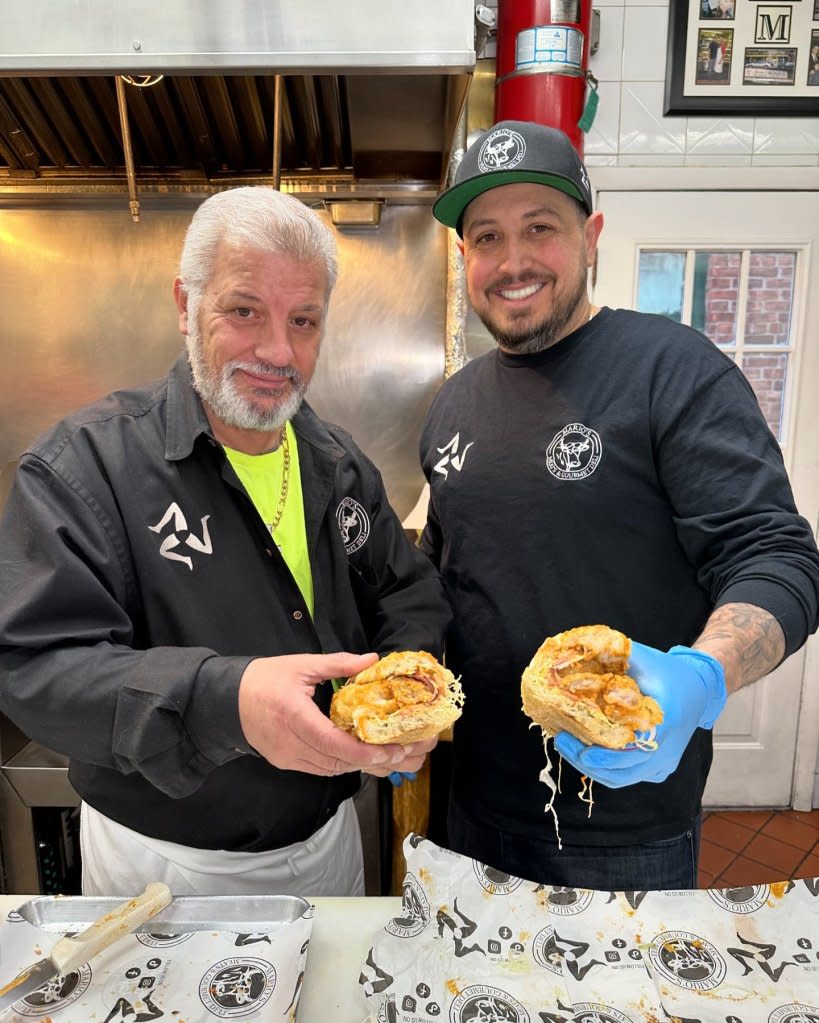 Joe DiGangi (right), the owner of Mario’s Meat Market and Gourmet Deli in Queens, and longtime worker Artie Spinelli pose with one of the shop’s delicious creations. Facebook/MariosMeats And Deli