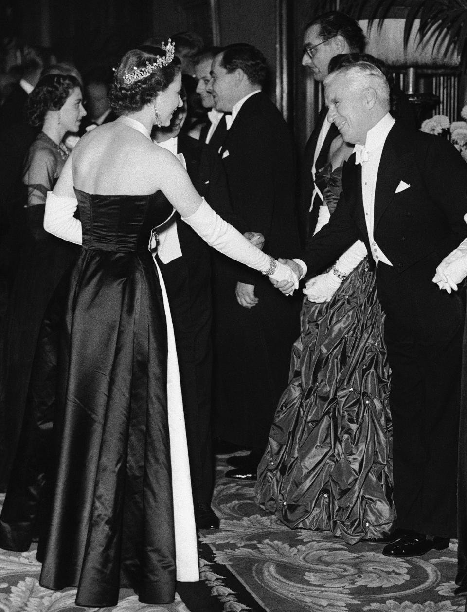 ARCHIVO – La reina Isabel II saluda al actor Charlie Chaplin en el Teatro Imperio en Londres el 27 de octubre de 1952 en una función real en apoyo al Fondo de Beneficencia Cinematográfica. (Foto AP)